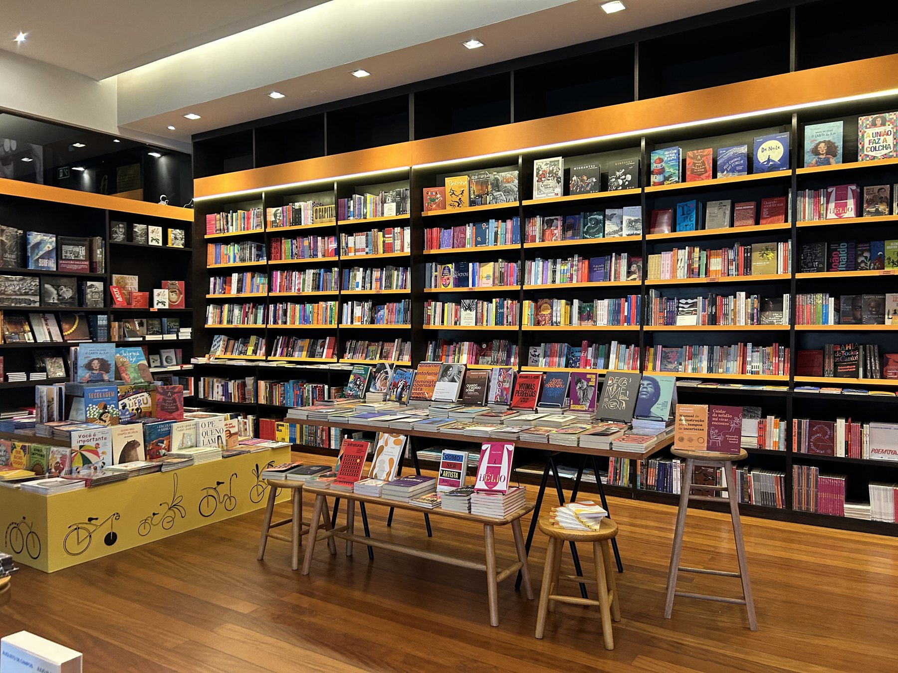 Vitrine da Livraria Terra Libris iluminada à noite, com a logo acesa no vidro